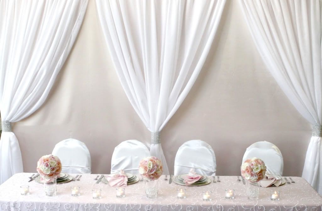 Pillar backdrops are created with iron pillars containing tulle and lights